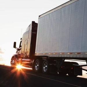 silhouette-of-a-commercial-truck-driving-on-a-highway-at-sunset-.jpg